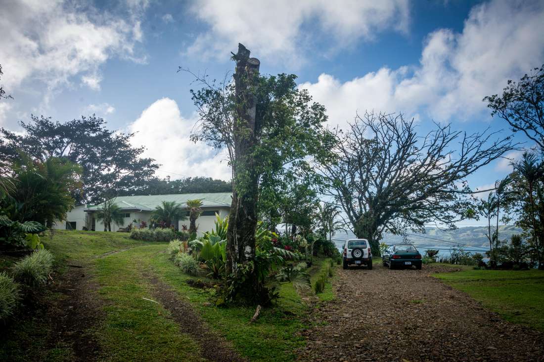 Entrada de la propiedad mostrando el lago Arenal, la parte trasera de las instalaciones y el parqueo